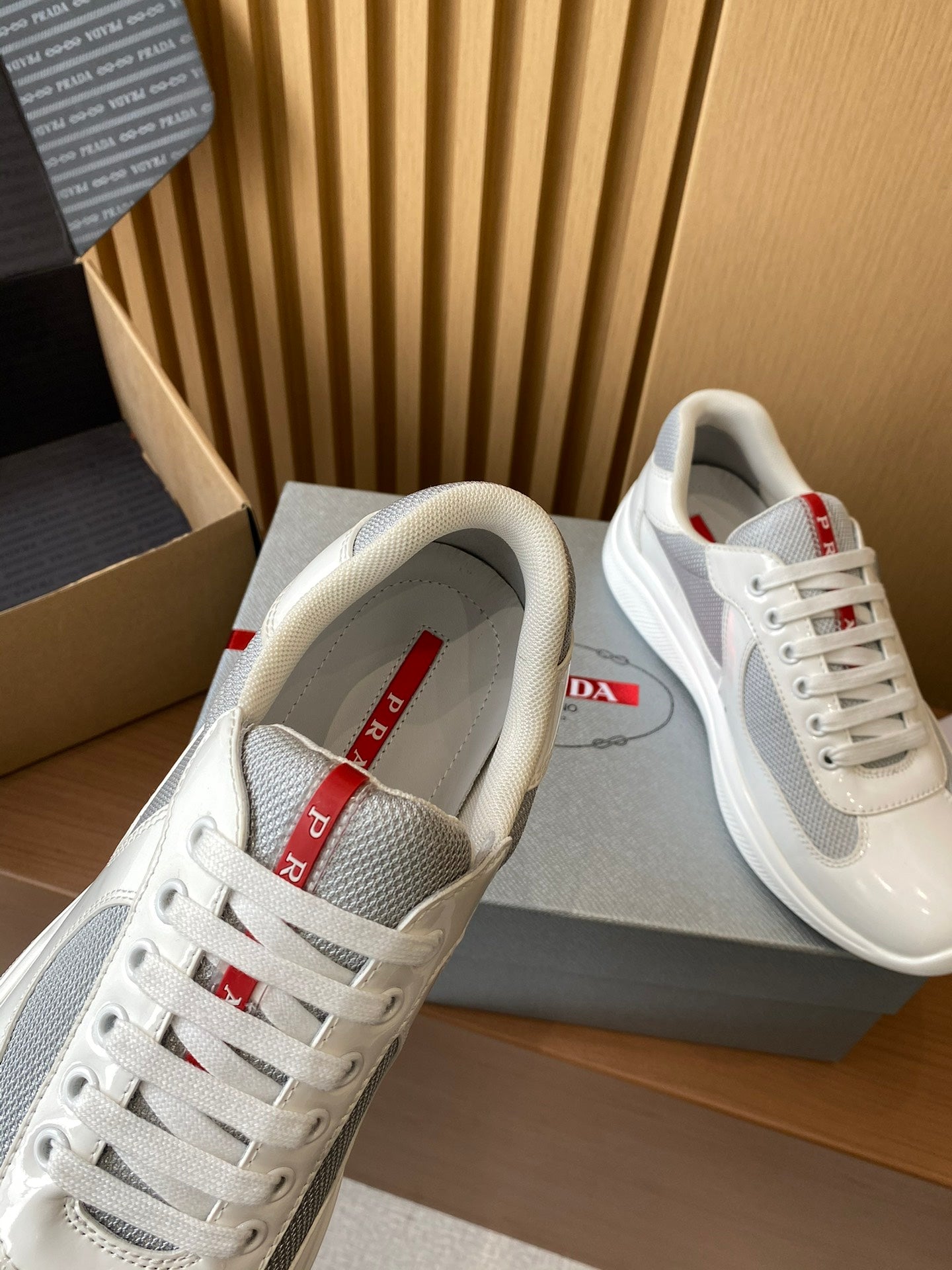 Prada unisex sneakers, white tongue strap with red detail, lace-up front