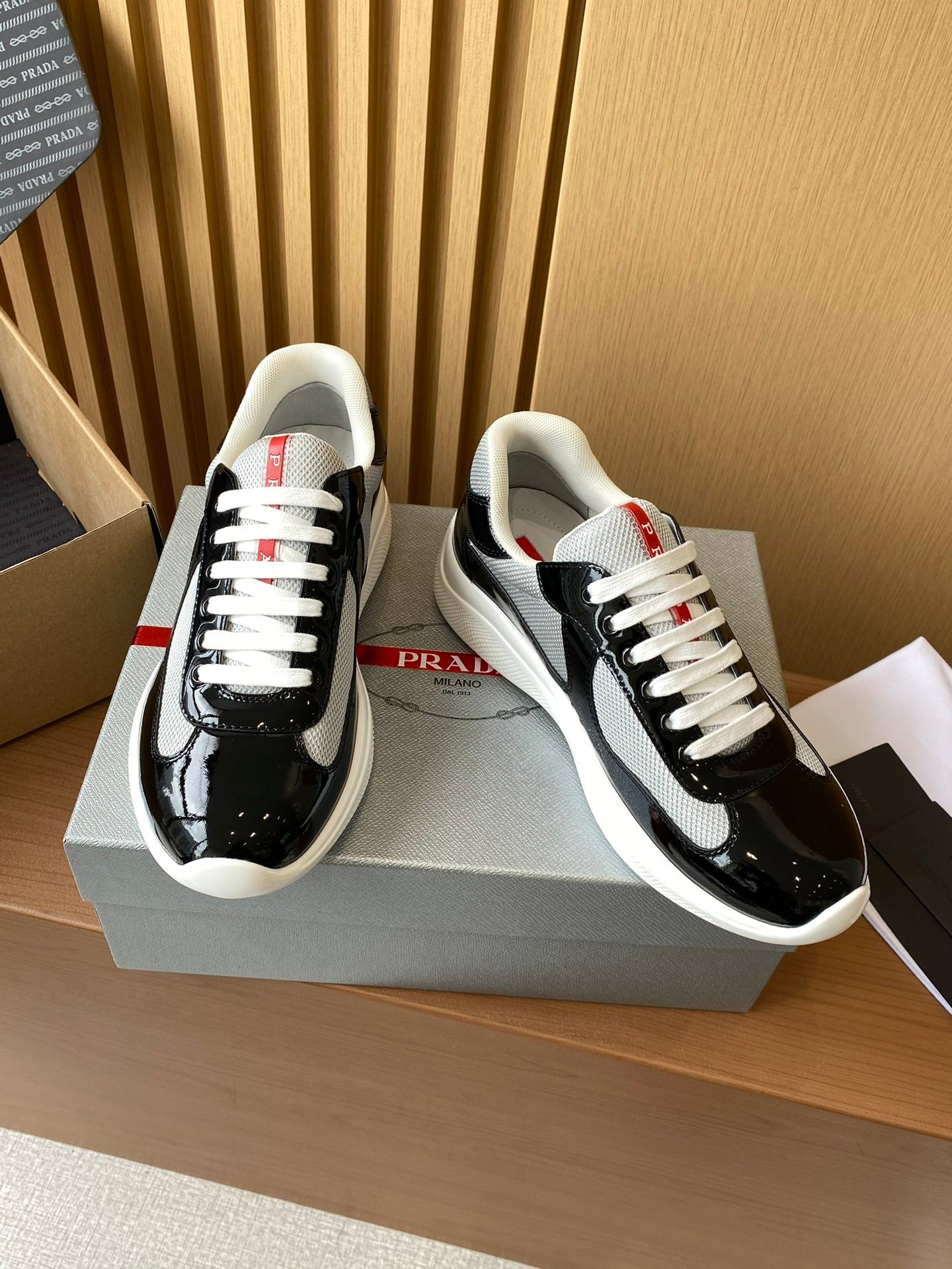 Prada unisex low-top sneakers, black patent leather with grey swoosh, white laces