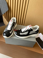 Prada unisex sneakers, black patent with grey swoosh, white laces and red heel tab