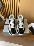 Prada unisex low-top sneakers, black patent with grey swoosh and white laces