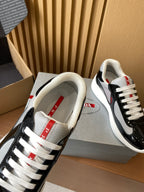 Prada unisex sneakers, black patent with white mesh lining and red tongue label