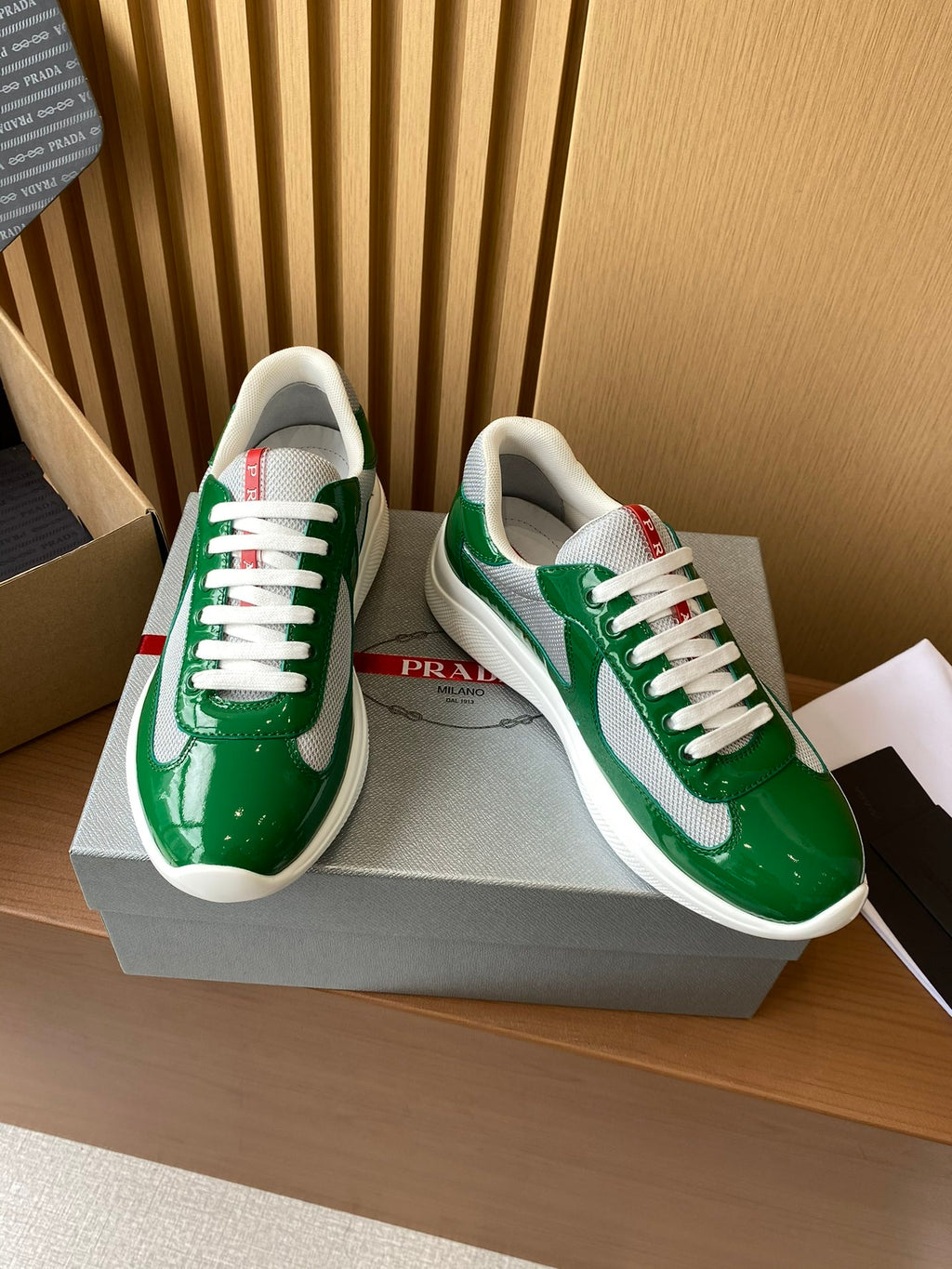 Prada unisex green patent sneakers with white laces and red heel tab