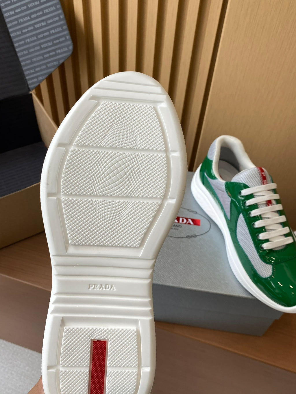 Prada unisex sneaker outsole with textured white tread and red heel marking