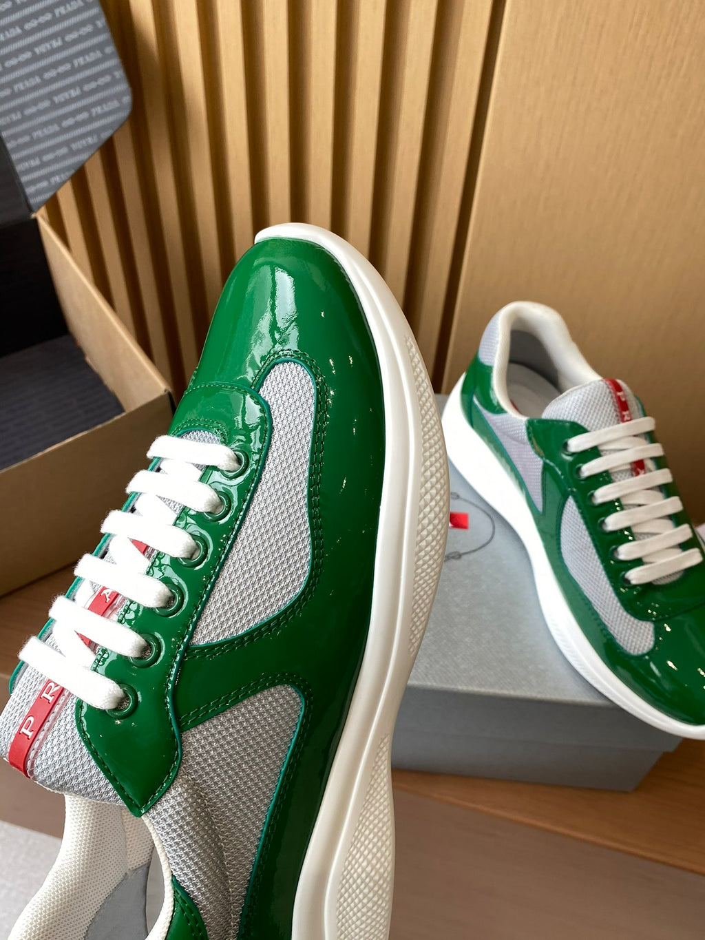 Prada unisex green patent sneaker with white mesh panel and lace-up front