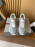 Unisex sneakers in light gray with white laces and red logo accents, on a shoebox