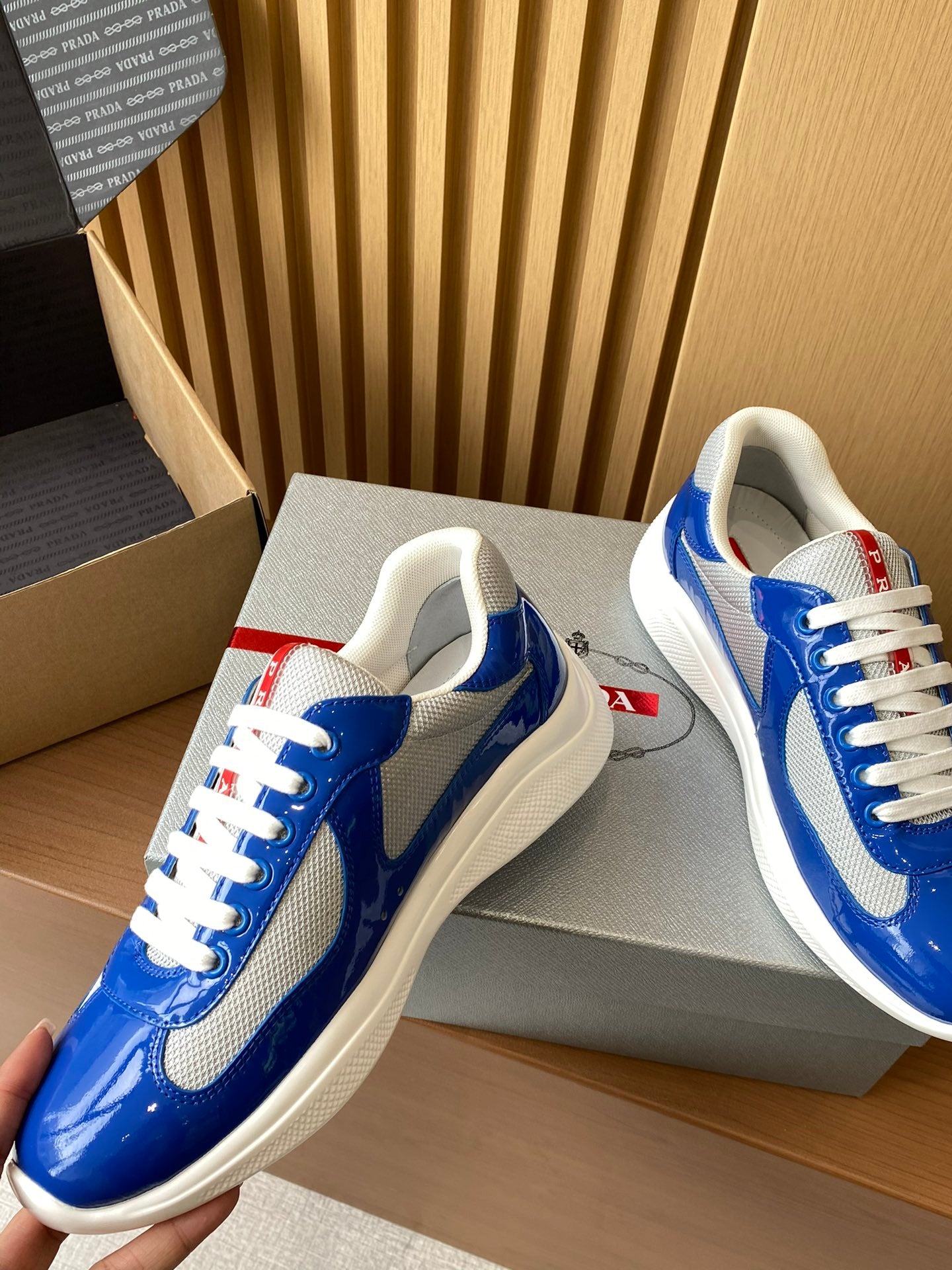 Prada unisex sneakers close angle, blue leather with white laces and gray swoosh
