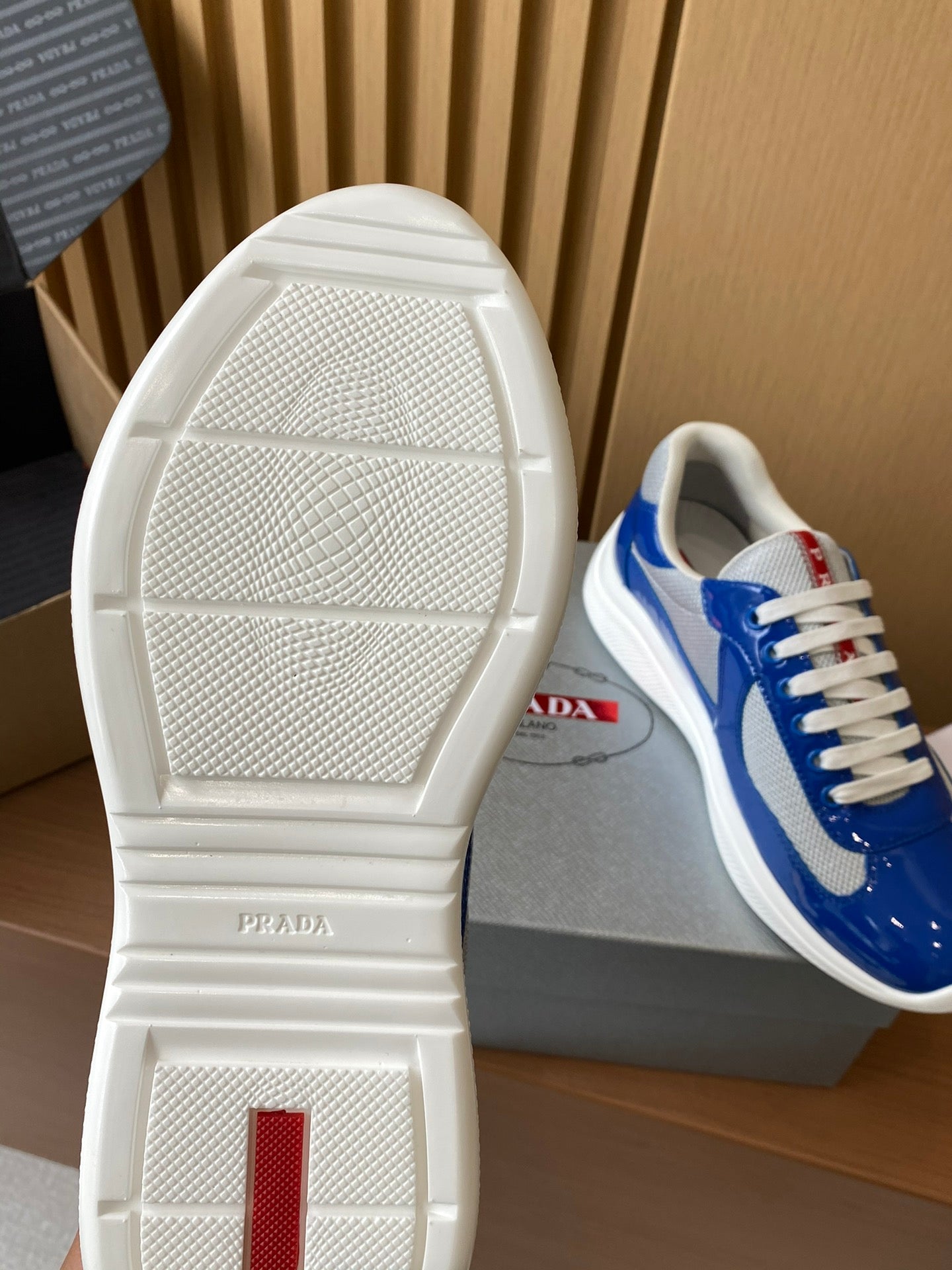 Prada unisex sneaker outsole view, textured white sole with heel branding