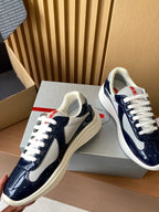 Prada low-top sneakers in navy and white, close view of two shoes with laces