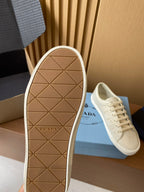 Prada unisex sneaker outsole, cream rubber tread with Prada lettering at heel.
