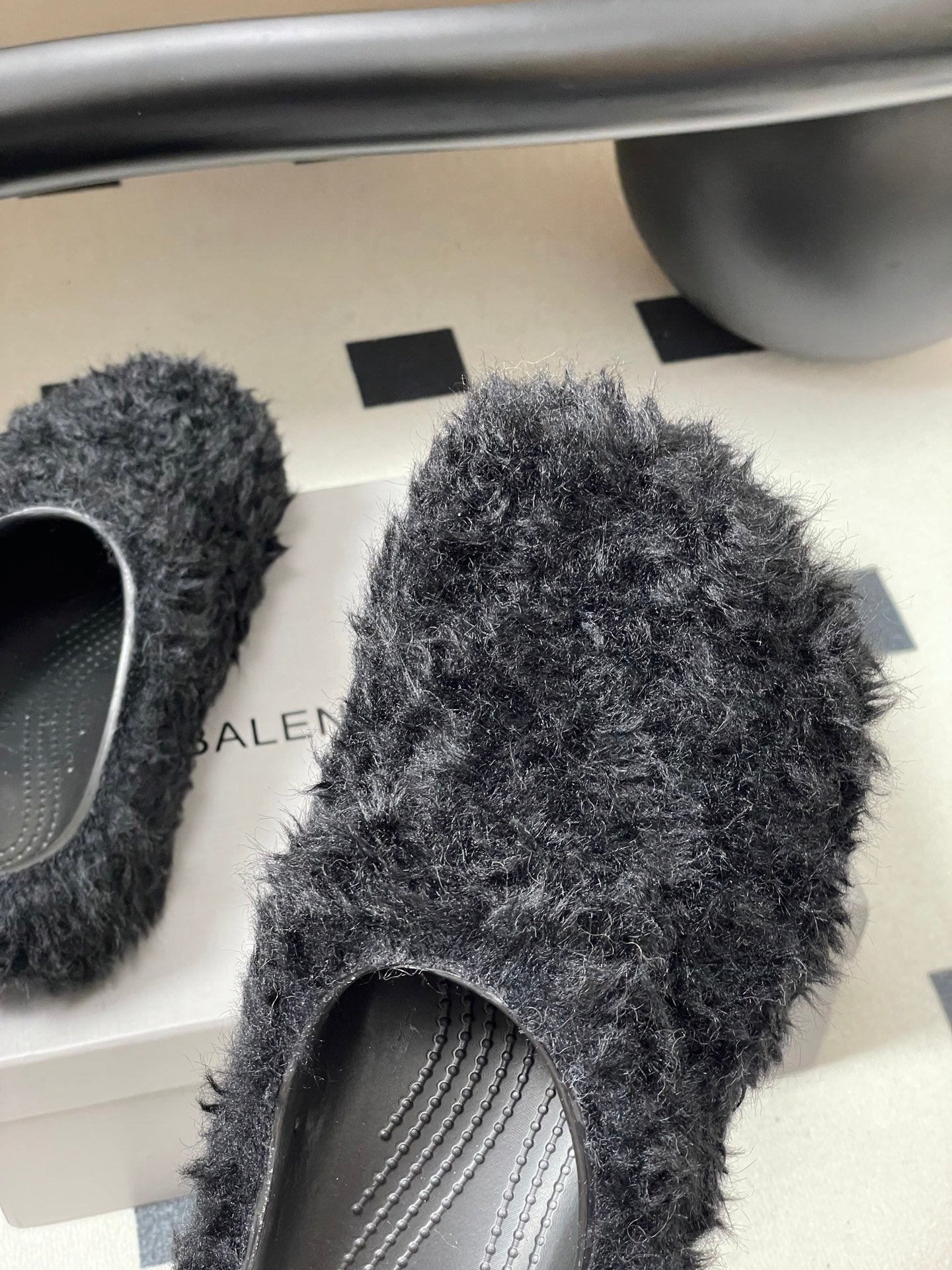 Black shaggy slide sandals with gray striped insole detail and rounded toe