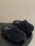 Black fuzzy slide sandals with gray rubber footbeds