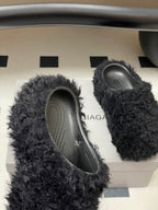 Black fuzzy slide sandals with oval opening and gray patterned insoles