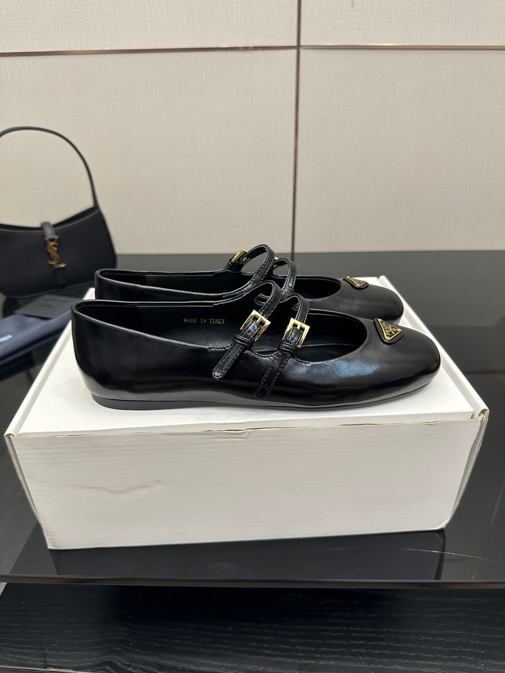 Prada women's black leather loafer with two front straps and gold-tone buckle