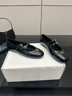 Prada women's black leather loafers with gold buckle detail, rounded square toe