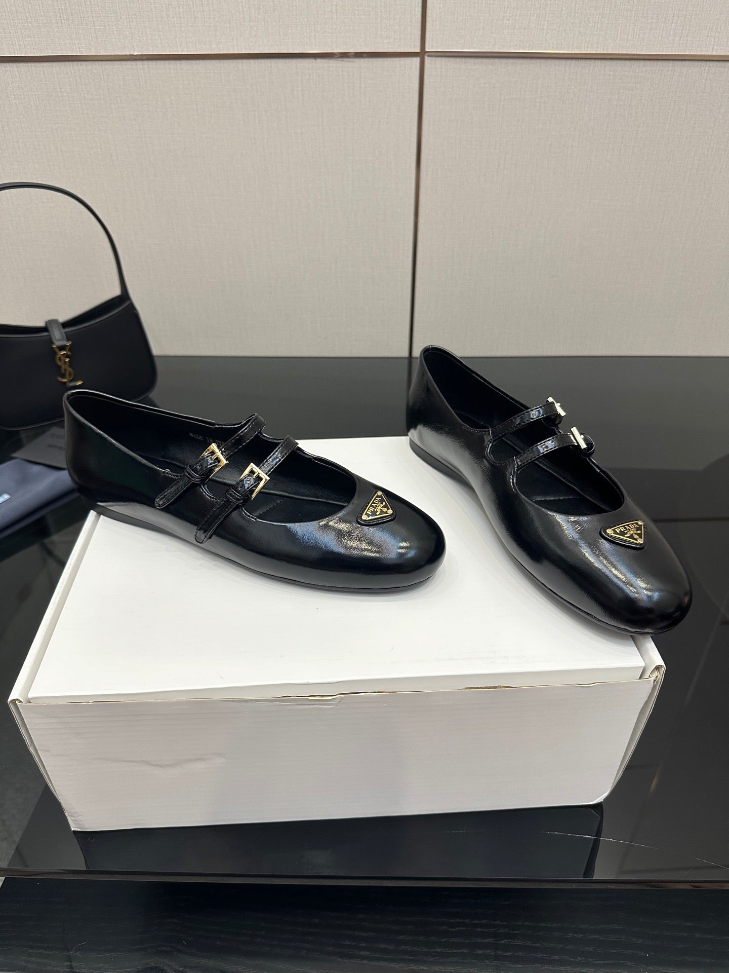 Prada women's black leather loafers with gold buckle detail, rounded square toe