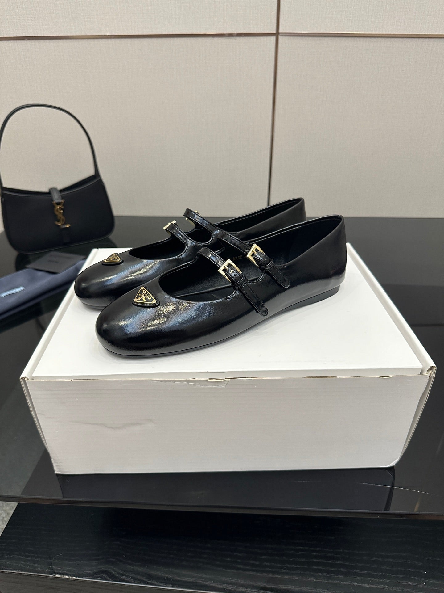 Prada women's black leather loafers with front strap buckles and low heel