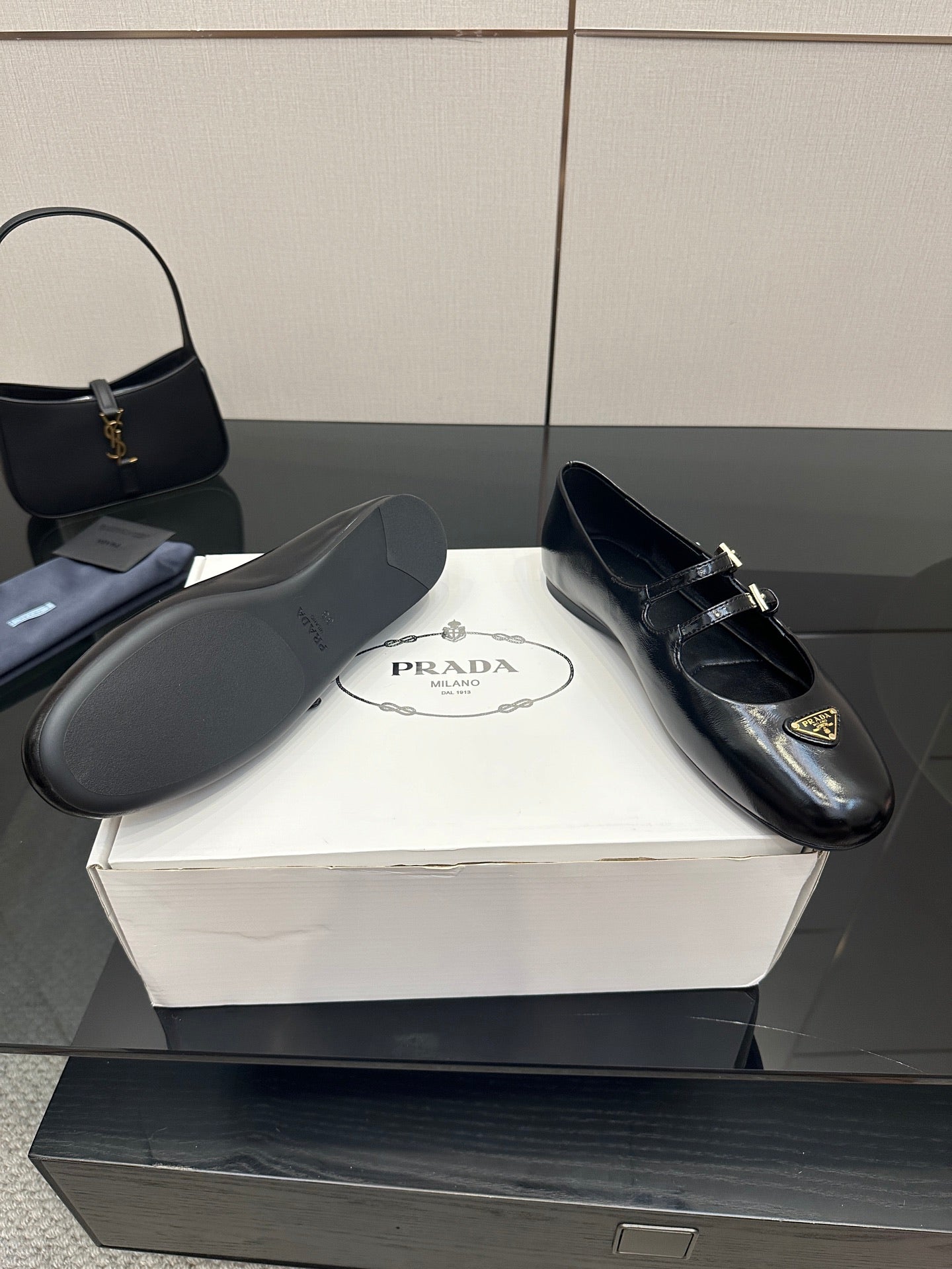 Prada women's black leather loafers with gold-tone buckle straps, top view