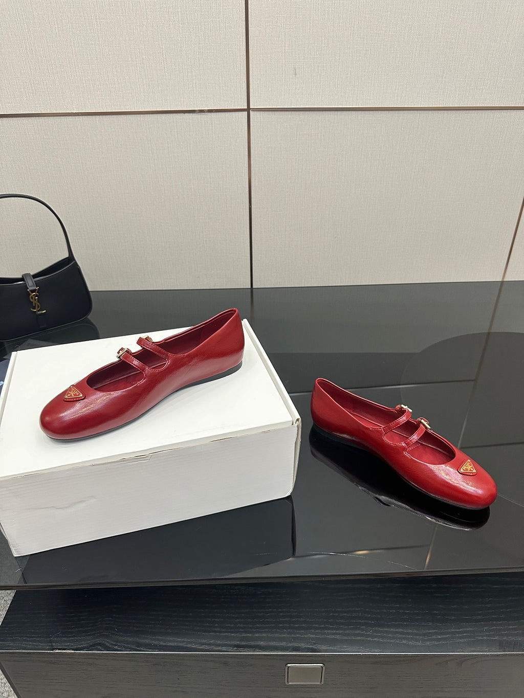 Prada women’s red leather loafers with gold logo plaque and strap buckles, pair view