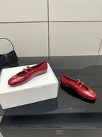 Prada women’s red leather loafers with gold logo plaque and strap buckles, pair view