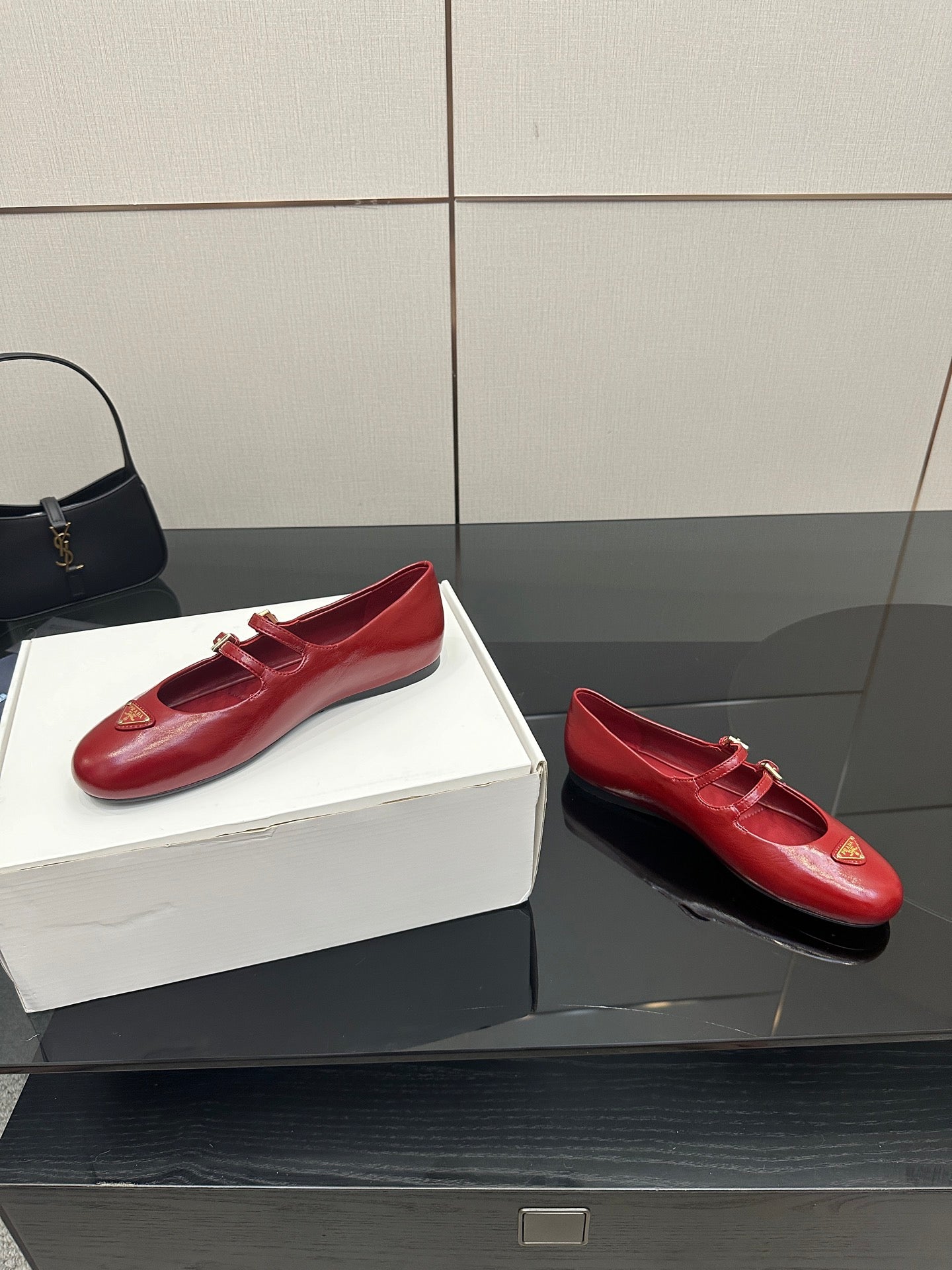 Prada women’s red leather loafers with gold logo plaque and strap buckles, pair view