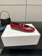 Prada women’s red leather loafer with front strap and gold logo plaque, close angle