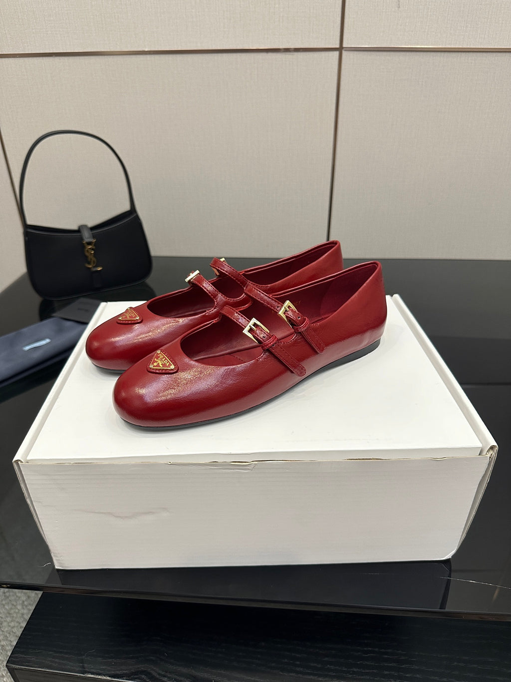 Prada women’s red leather loafers with gold logo plaque and strap detail