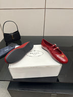 Prada women’s red leather loafers with gold logo plaque and buckled strap, side angle