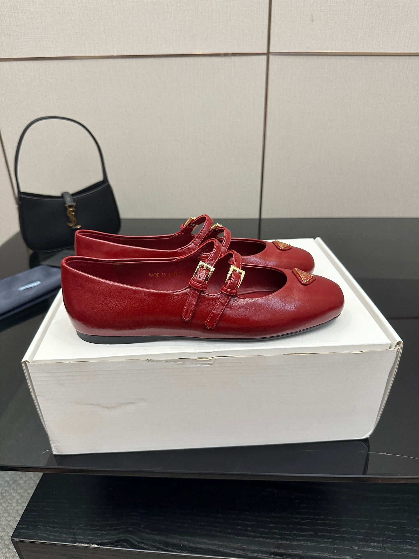 Prada women’s red leather loafers with front strap and gold logo plaque