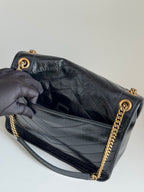 YSL bag open to dark lining, showing quilted leather and gold chain strap