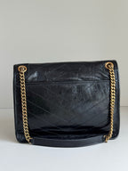 YSL quilted flap bag with gold chain strap and YSL logo on the front