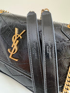 Black quilted leather bag with gold YSL logo and metal loop hardware