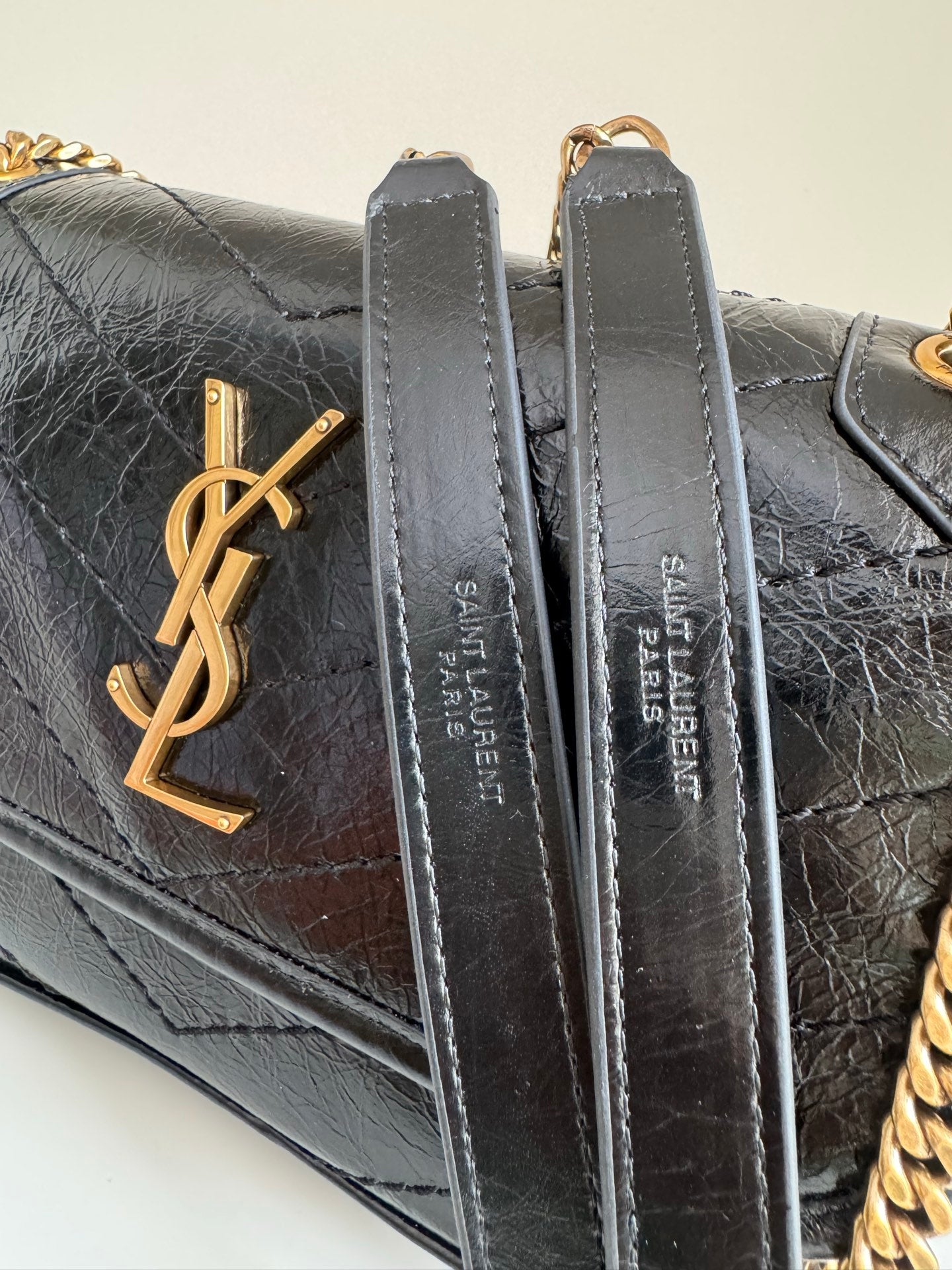 Black quilted leather bag with gold YSL logo and metal loop hardware