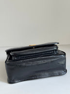 Black leather shoulder bag with structured shape, front flap seam, and top edge