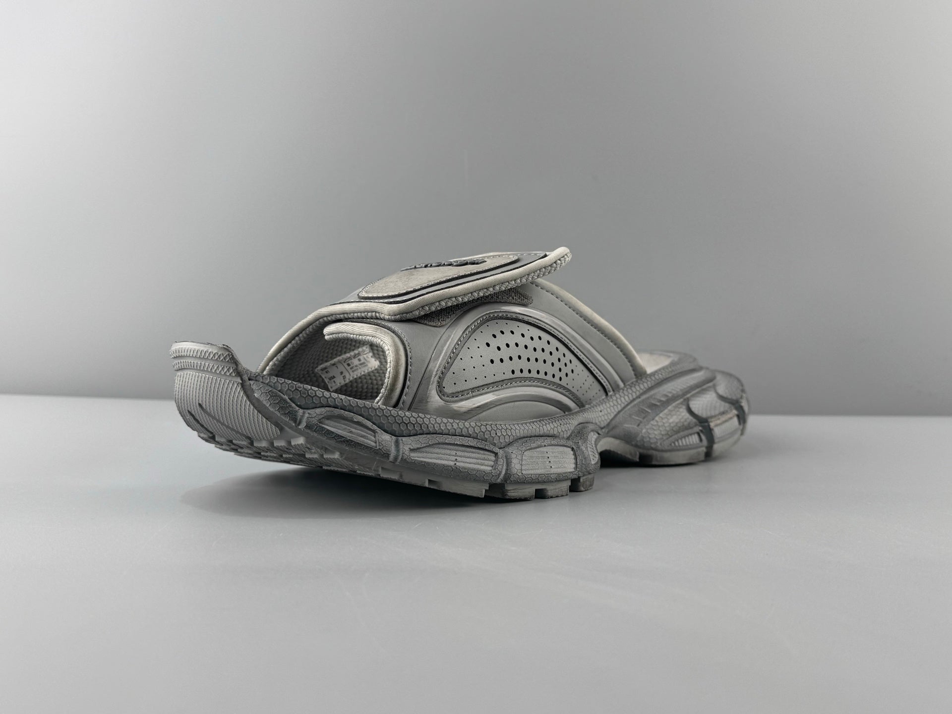 Light gray slide sandals with perforated upper and ribbed chunky sole