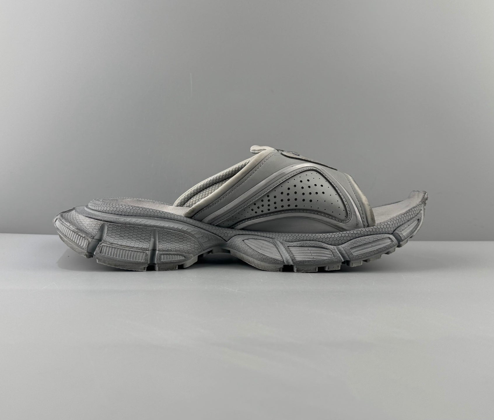 Light gray slide sandals with perforated top and cushioned straps