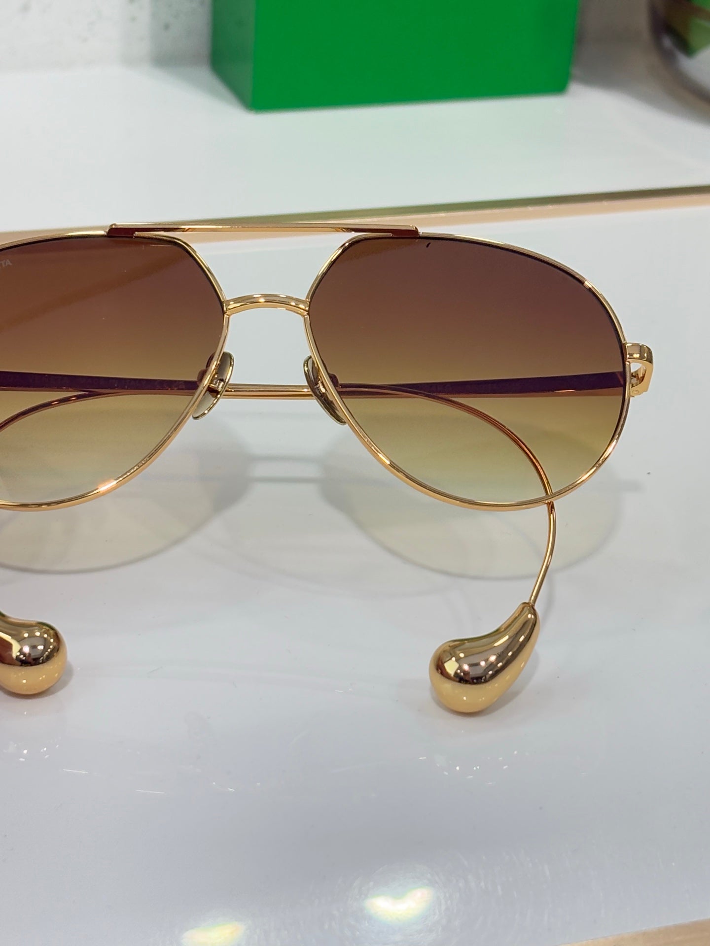 Gold-tone round sunglasses close-up with tinted lenses and metal bridge