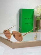 Gold-tone sunglasses with brown lenses and slim metal arms