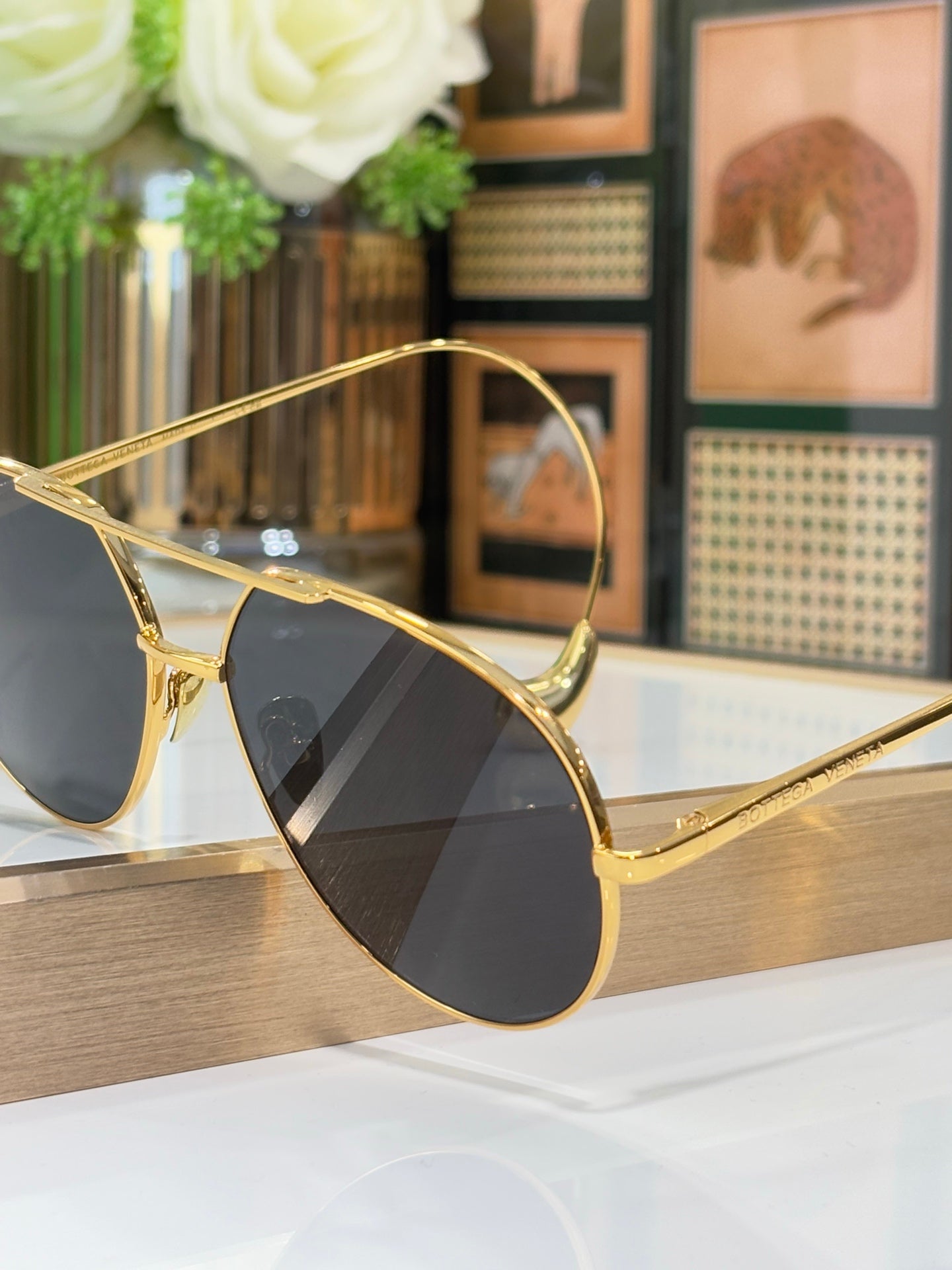 Gold-tone sunglasses angled profile with dark lenses and slim metal frame