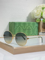 Gucci round sunglasses with gold-tone frame and blue-tinted lenses