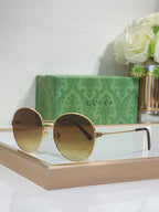 Gucci round sunglasses with gold-tone frame and dark blue gradient lenses
