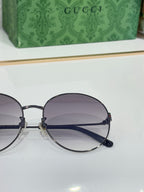 Gucci round sunglasses close-up with dark frame and purple gradient lenses