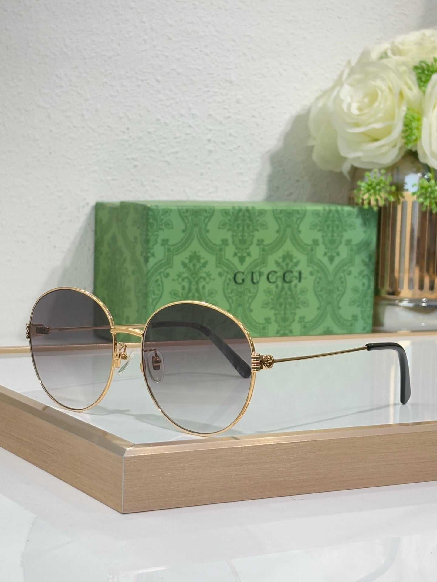 Gucci round sunglasses with gold-tone metal frame and blue-tinted lenses