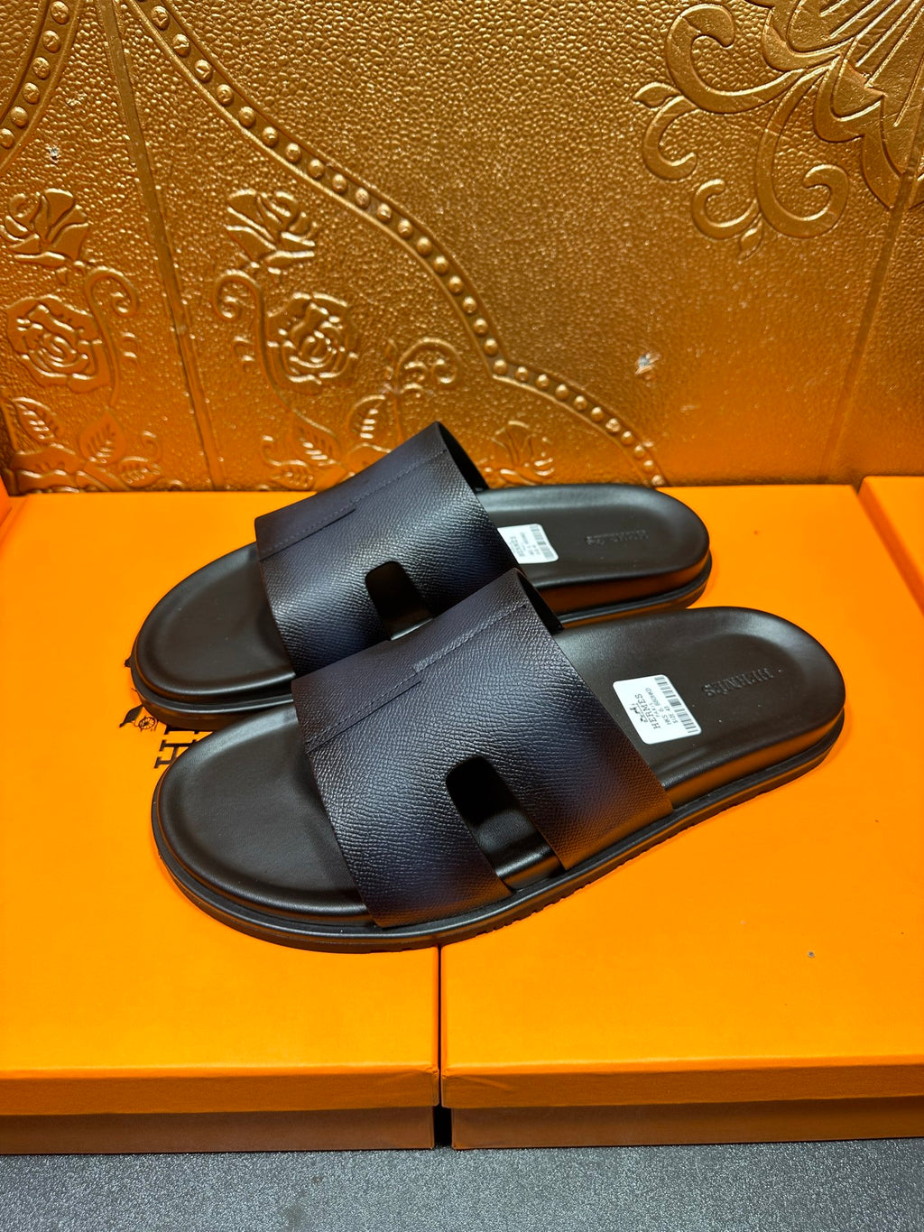 Hermes dark leather slide sandals with wide strap and open toe, side view