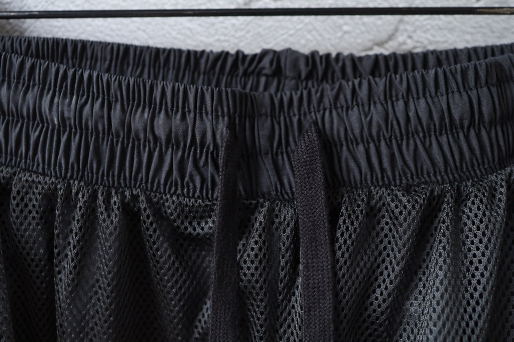 Dark elastic waistband with mesh-like panel detail on pants