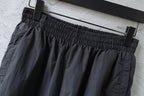 Black pants with elastic waistband and belt-loop detail at the top