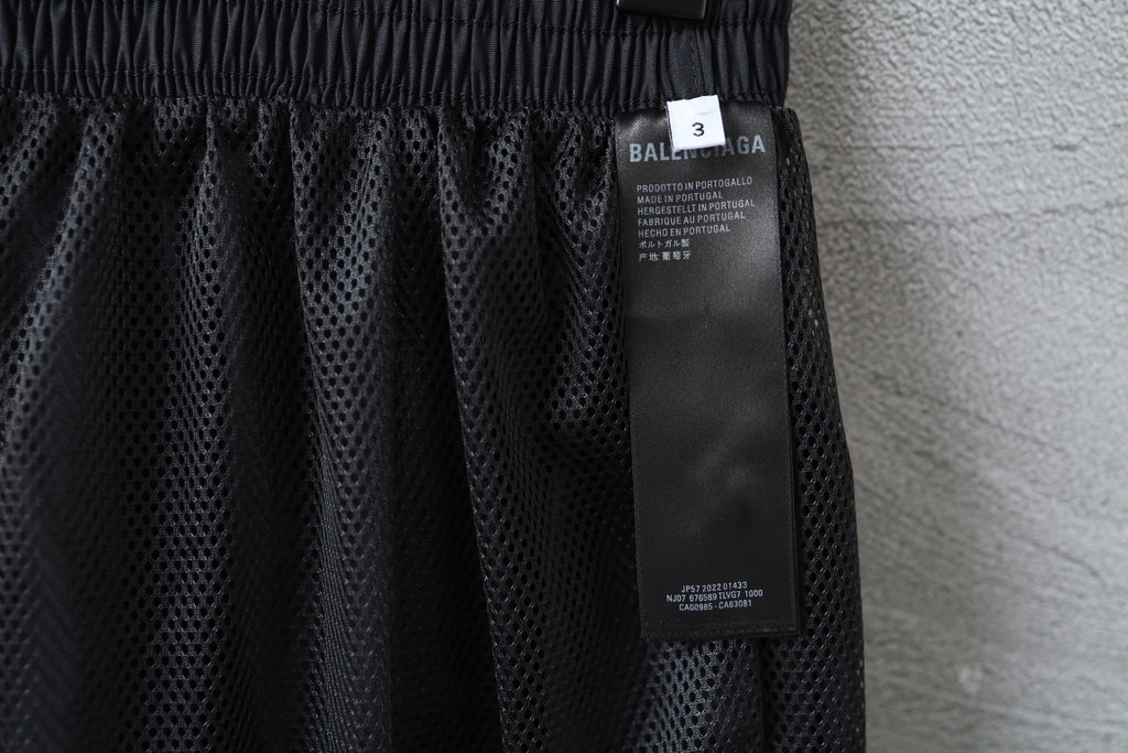 Dark pants with mesh-like fabric panel and attached size label