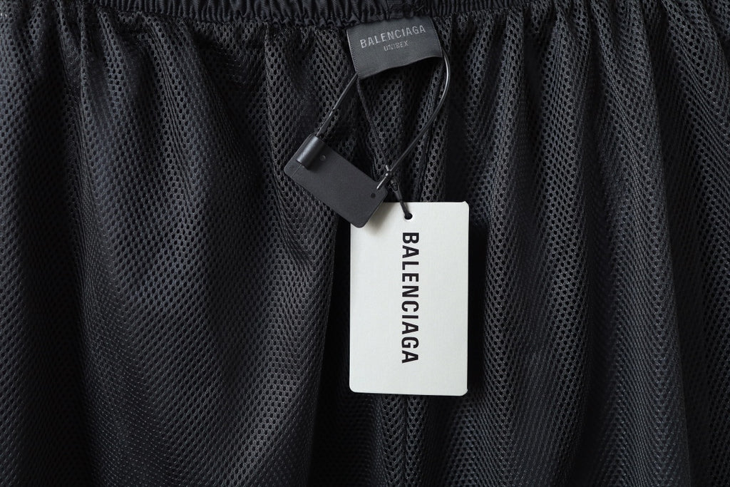 Dark mesh panel pants with black Balenciaga hang tag