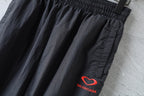 Black pants with elastic waistband and red BALENCIAGA logo at side.