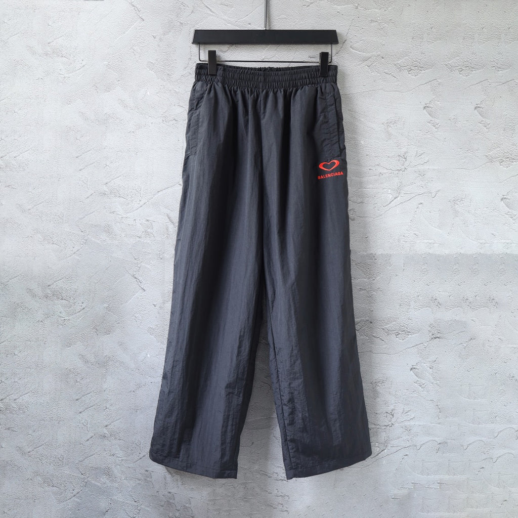 Black Balenciaga wide-leg pants with elastic waistband and red heart logo patch