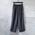 Black Balenciaga wide-leg pants with elastic waistband and red heart logo patch